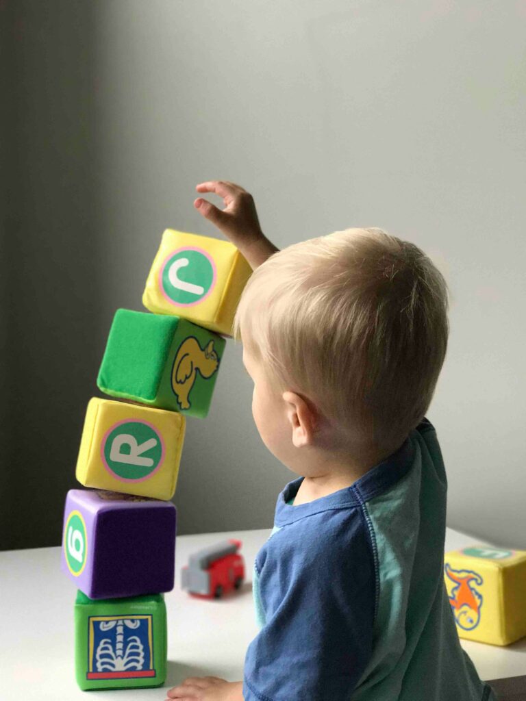 Young boy stacking colorful blocks