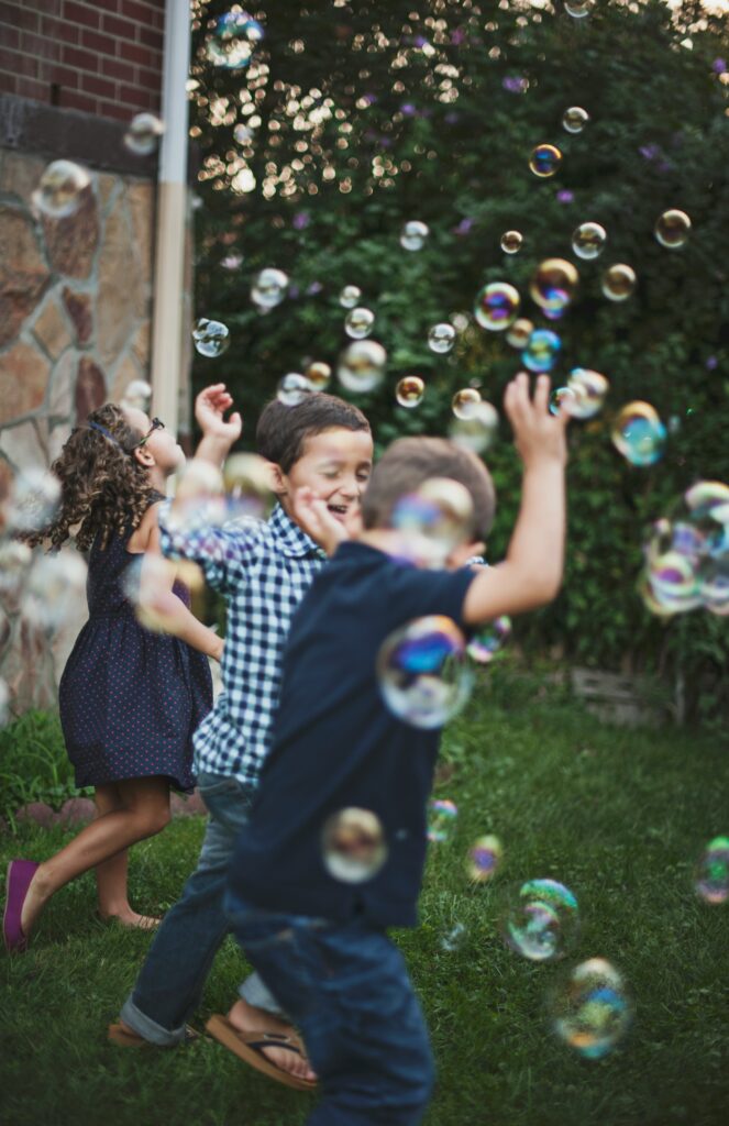 kids running through bubbles