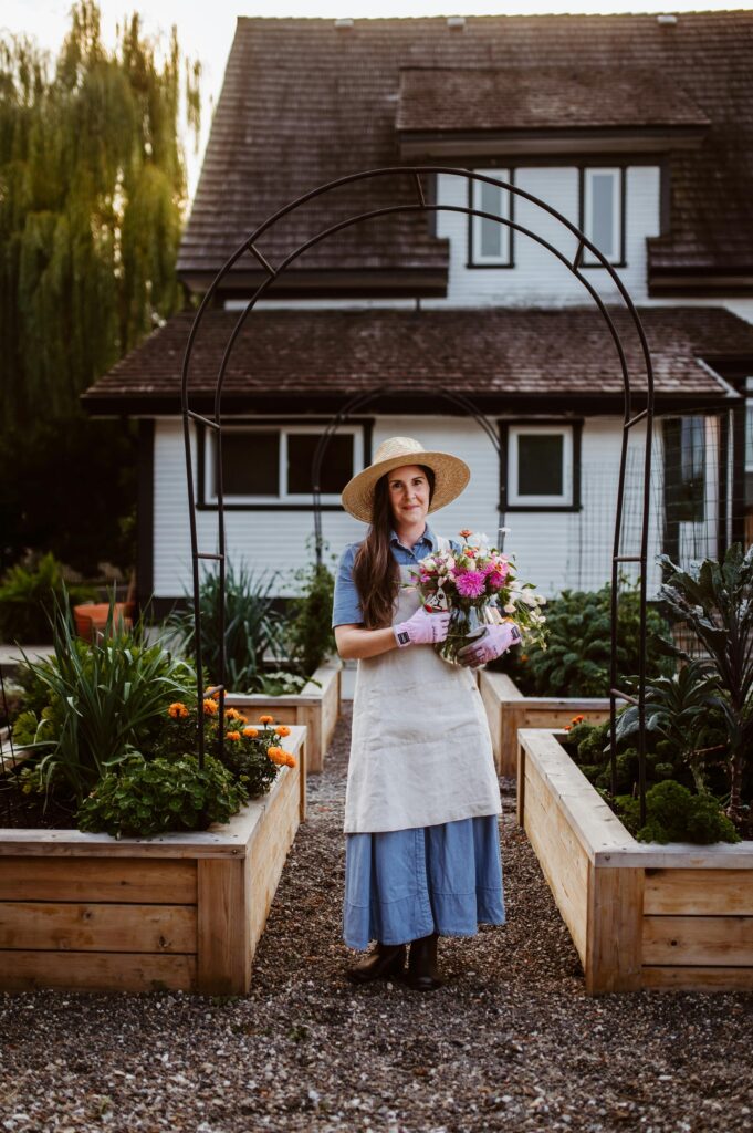 woman standing in her garden with flowers in her arms