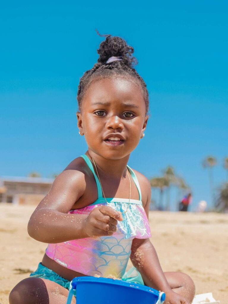 toddler girl playing with sand at the beach