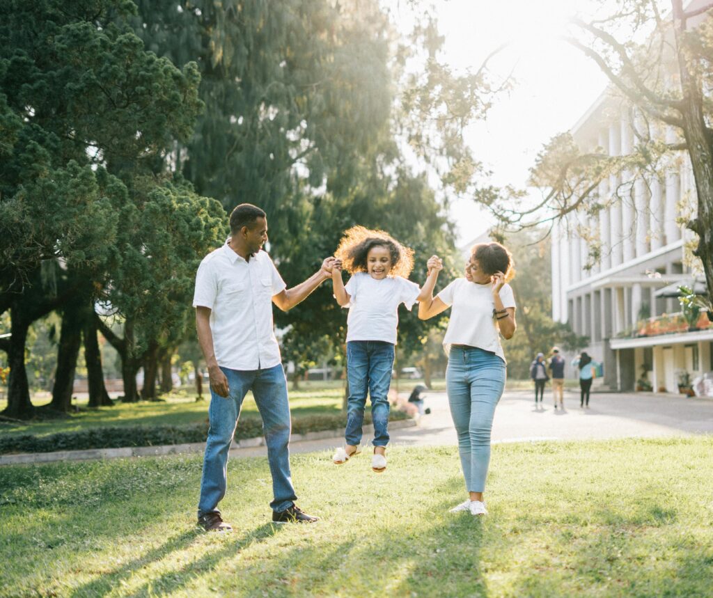 a man and woman assisting a girl while jumping