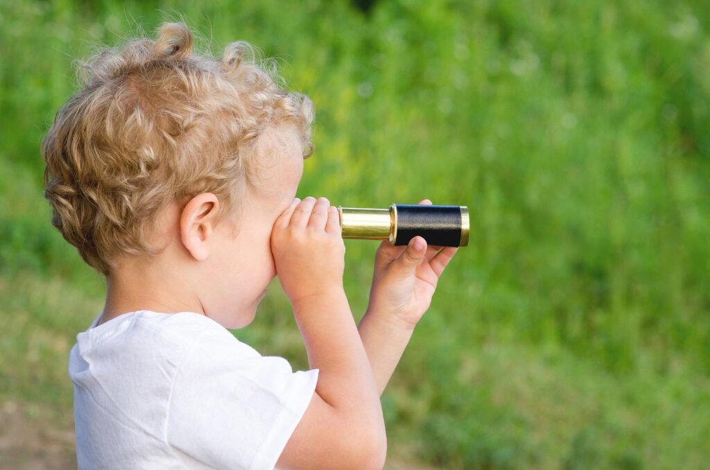 child looking through a spy glass