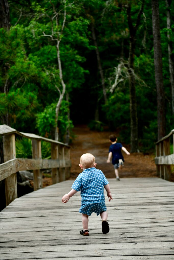 Two young boys leading the way across a bridge on the trail