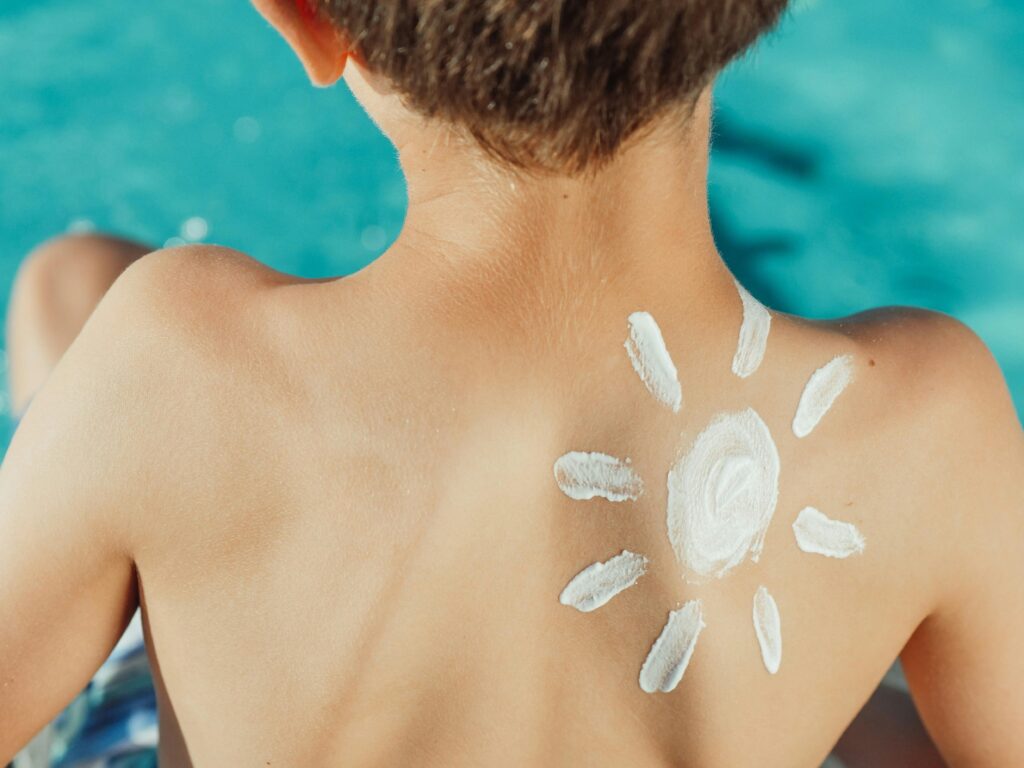 sun drawn in sunscreen on child's back