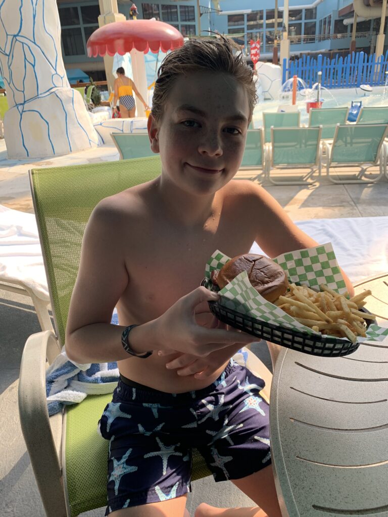 Kid holding a basket of fries and hamburger